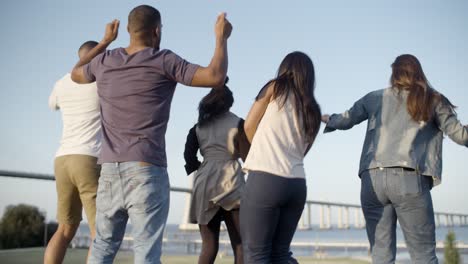 vista trasera de jóvenes bailando en el parque