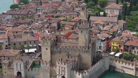 high angle of scaliger castle showing fortified walls and moat structure in crystal-clear waters