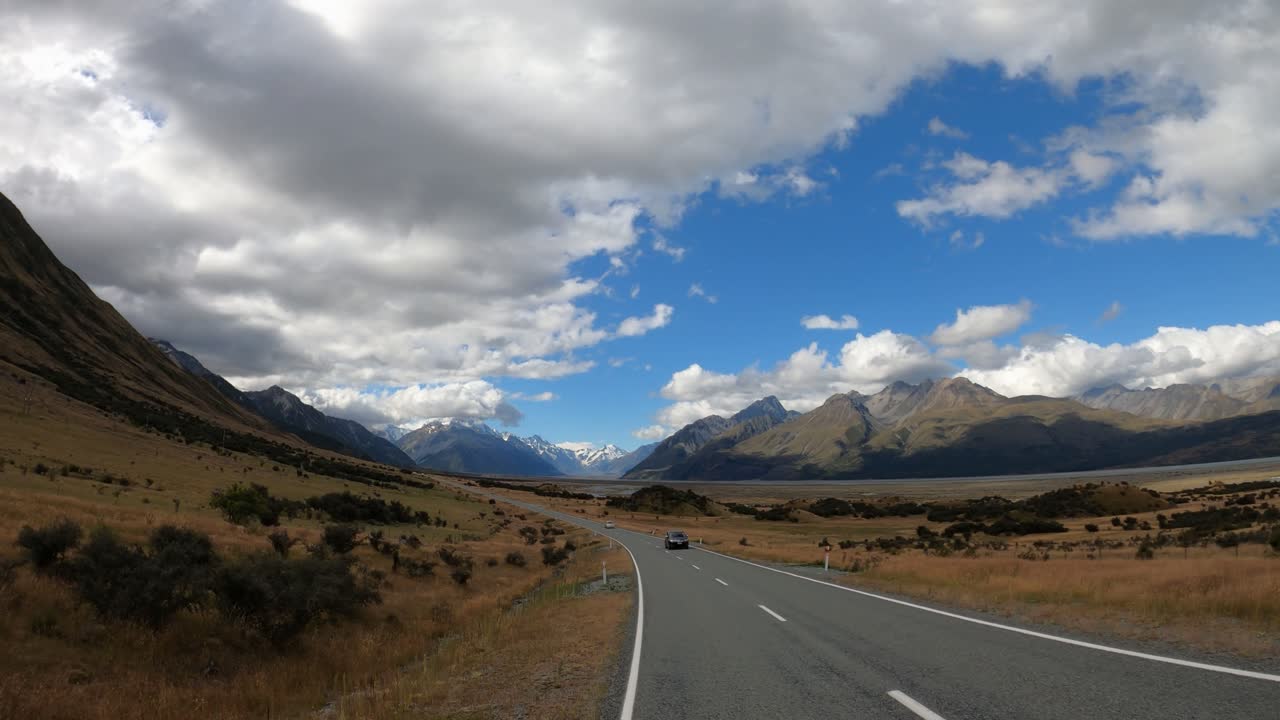 Breathtaking view from a car driving into the mountains of Mt. Cook, New Zealand. Beautiful scenery shot handheld from a window with gopro in 4k on cloudy summer day.
