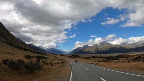 breathtaking view from a car driving into the mountains of mt. cook, new zealand. beautiful scenery shot handheld from a window with gopro in 4k on cloudy summer day.