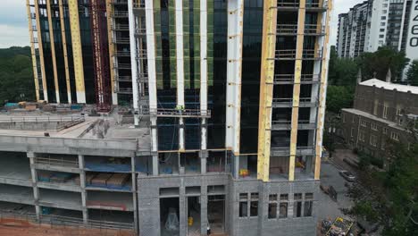 aerial orbit shot of construction site on new skyscraper tower in atlanta city