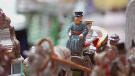 antique porcelain figurines of a couple in a carriage