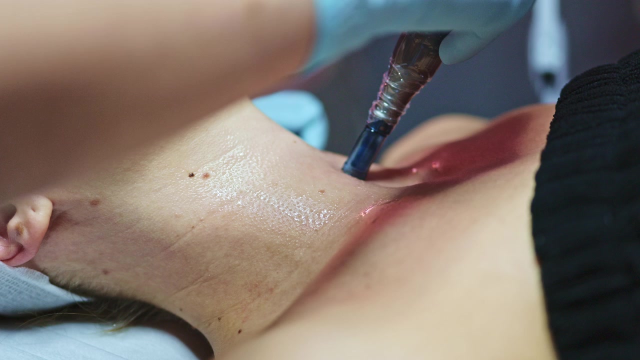 Un tatuatore applica l'inchiostro sulla pelle di un cliente durante una sessione di tatuaggio in uno studio nel pomeriggio