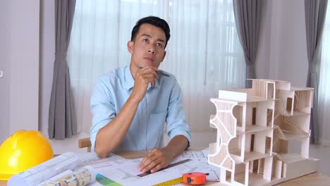 male designer at his workdesk thinking about new architectural ideas