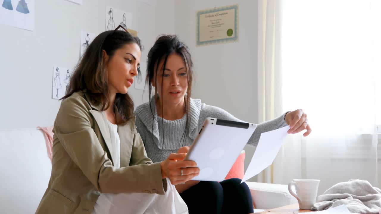 diseñadores de moda discutiendo sobre una tableta digital 4k