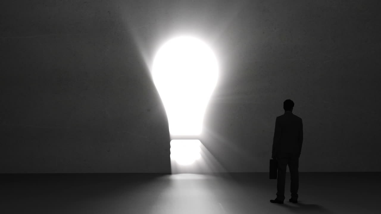 un hombre de negocios mirando una bombilla gigante.