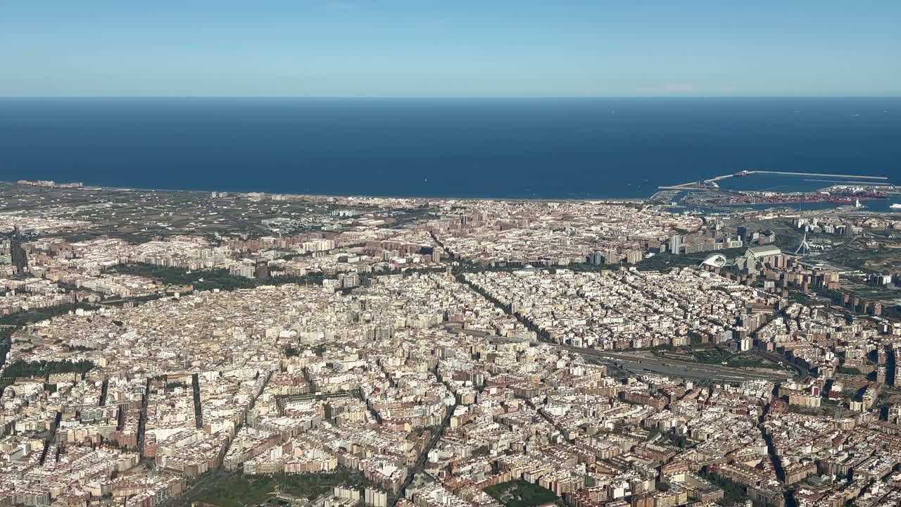 Aerial view of Valencia City center in Spain, in a splendid summer afternoon, recorded from the cockpit of a jet departing from the airport with a view of Harbor and Mediterranean Sea at the back. 4K
