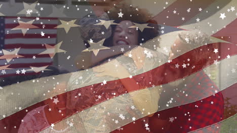 animation of flag of usa and stars over african american male soldier with family