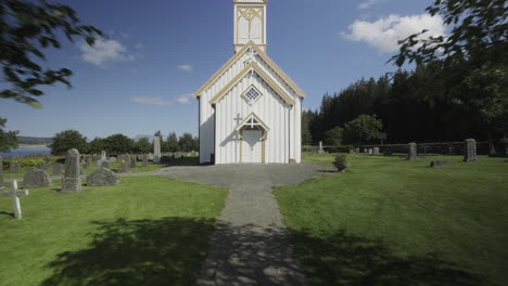 revealing a tiny white norwegian church, push in shot