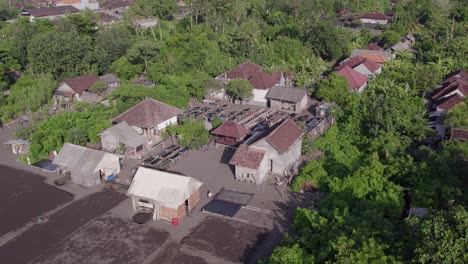 Aerial-view-of-organic-salt-farm-at-black-sand-beach-Bali-Indonesia,-drone-shot