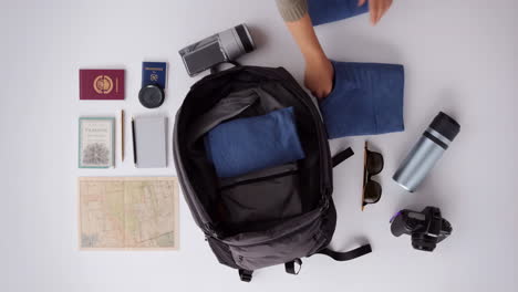 overhead view of person packing a backpack for a trip