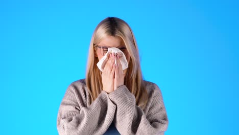 close-up ill woman sneezing in handkerchief, feeling unwell, studio shot