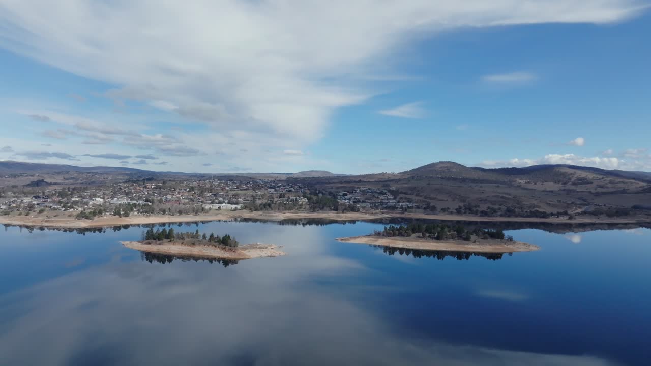 Aerial: Big wide shot of Jindabyne town and surrounding lake in the Snowy mountains, NSW Australia