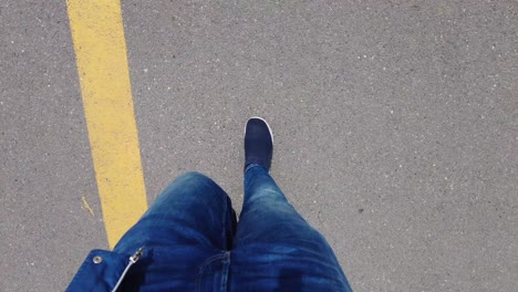 pov shot of man in shoe walking on road