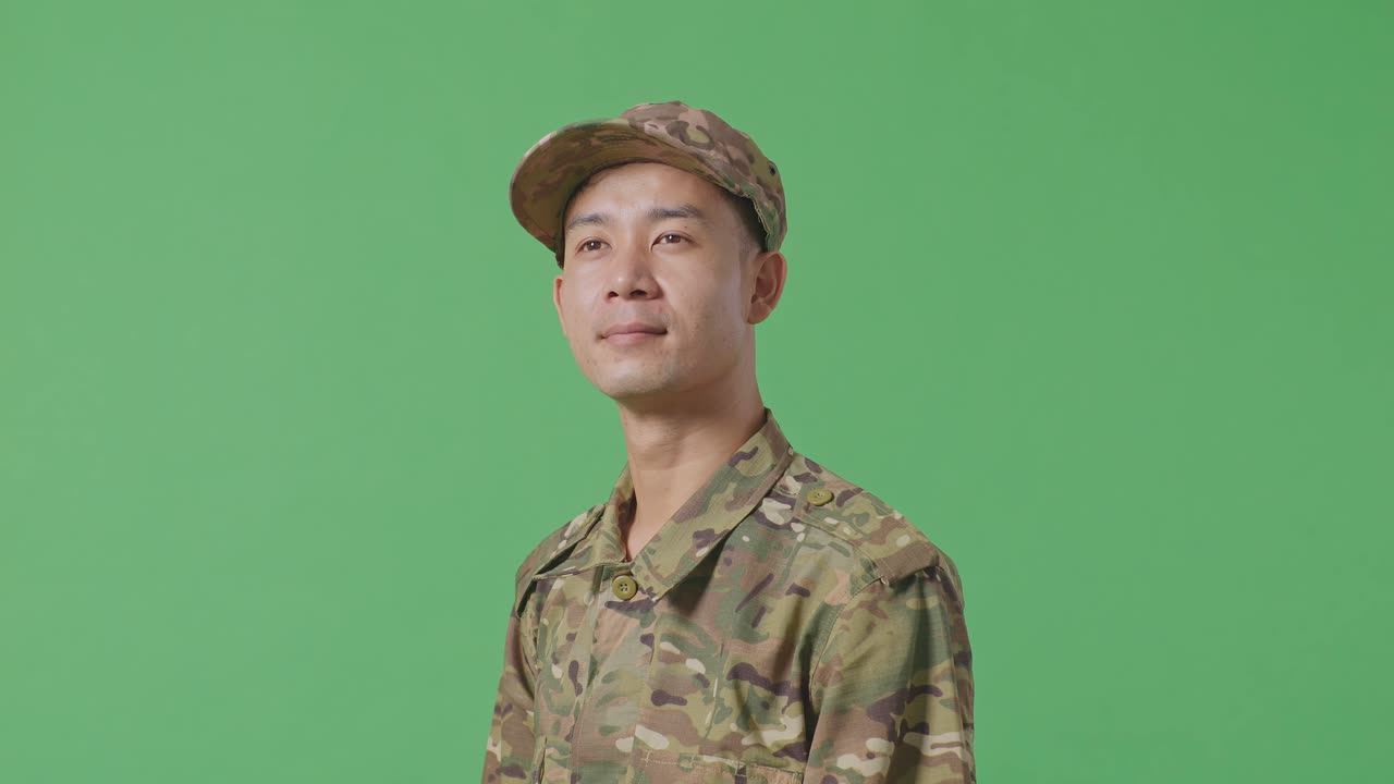 Close Up Of Side View Asian Man Soldier Looking Around While Standing In The Green Screen Background Studio