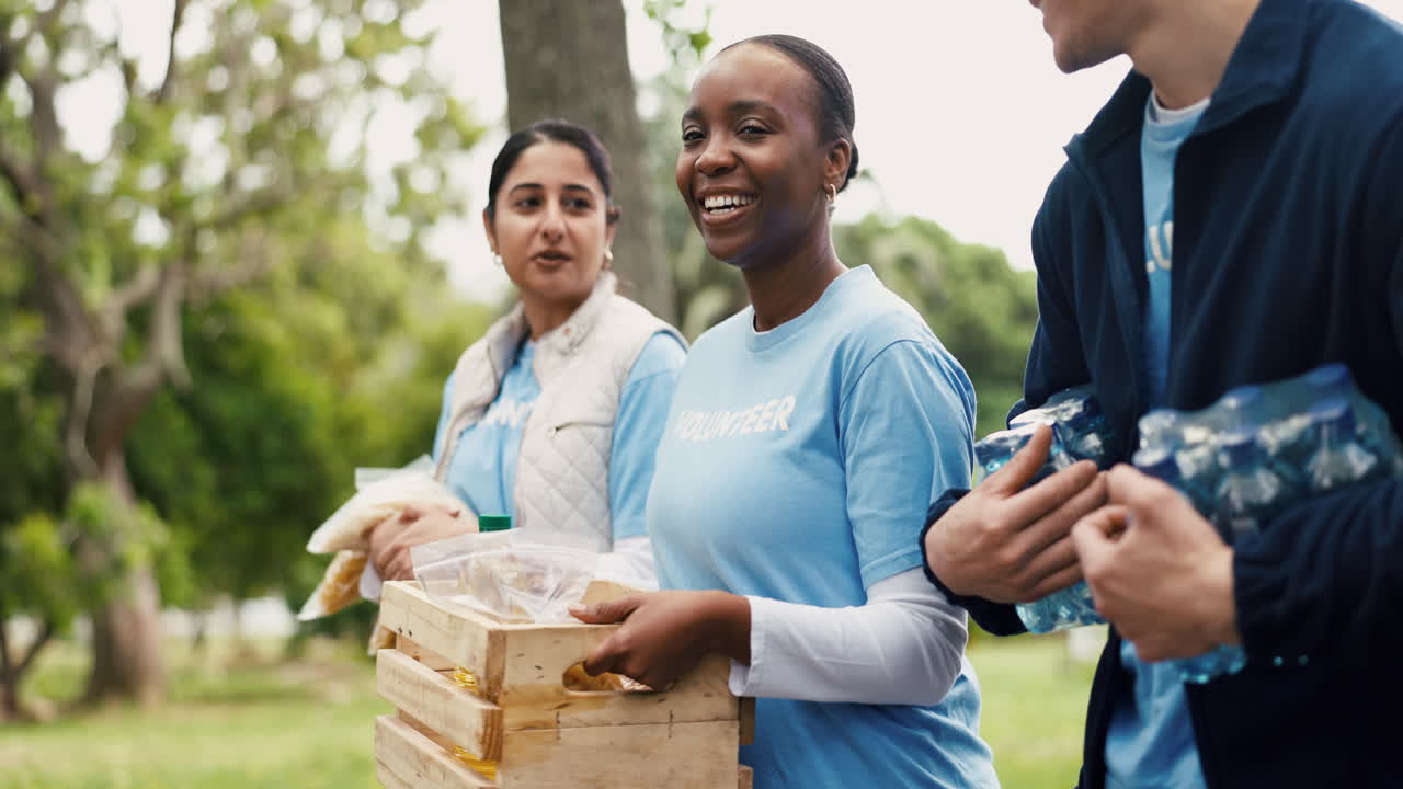 Happy Diverse Volunteers Distributing Food and Water in a Park