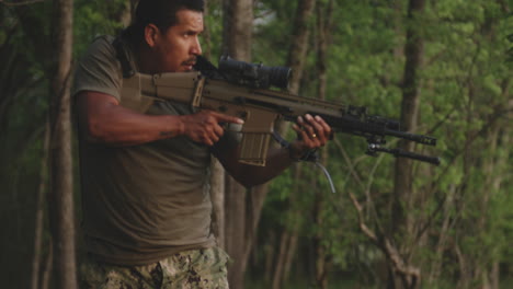 designated marksman hidden in the forest, aiming a fn herstal scar 17 rifle