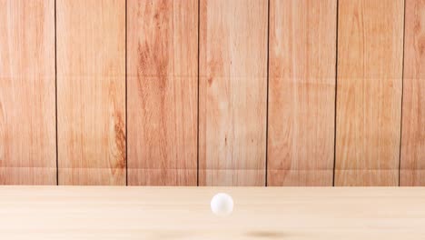 a ball moves across a wooden surface