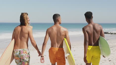 young men at the beach carrying surfboards 4k