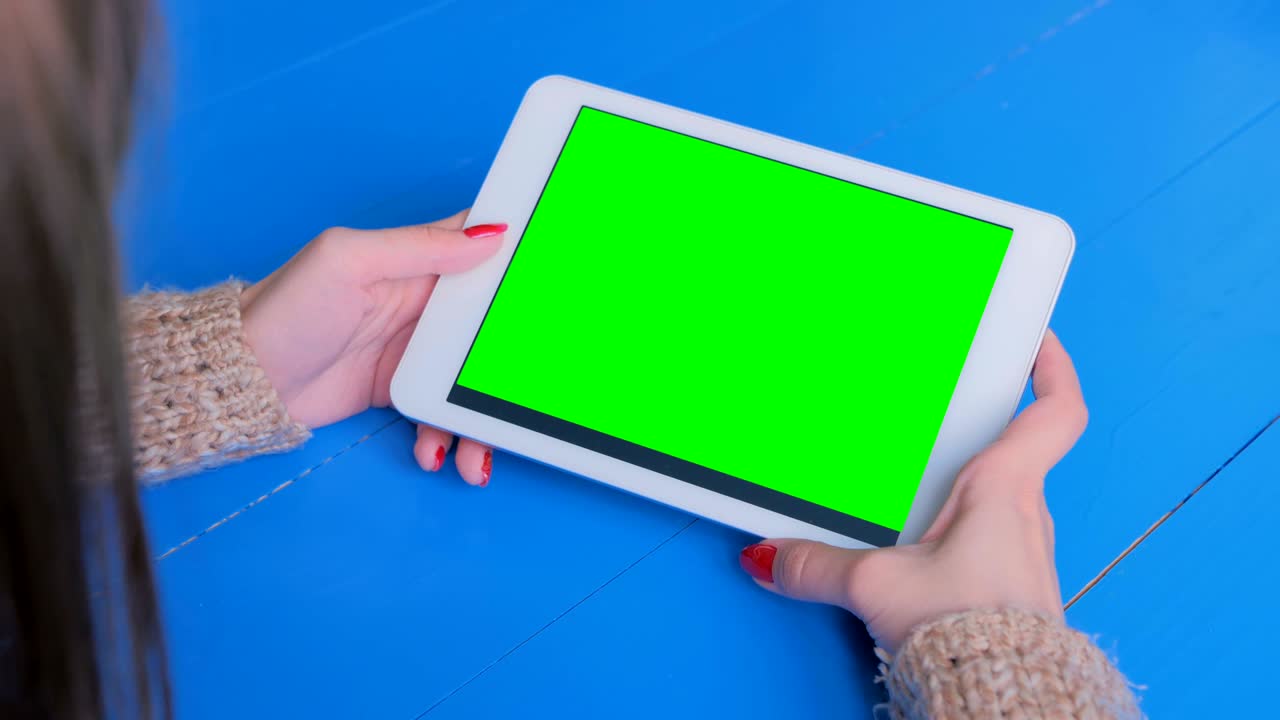 mujer mirando una tableta con pantalla verde