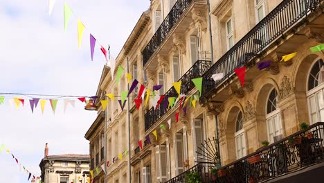 vibrant flags decorate historic bordeaux architecture