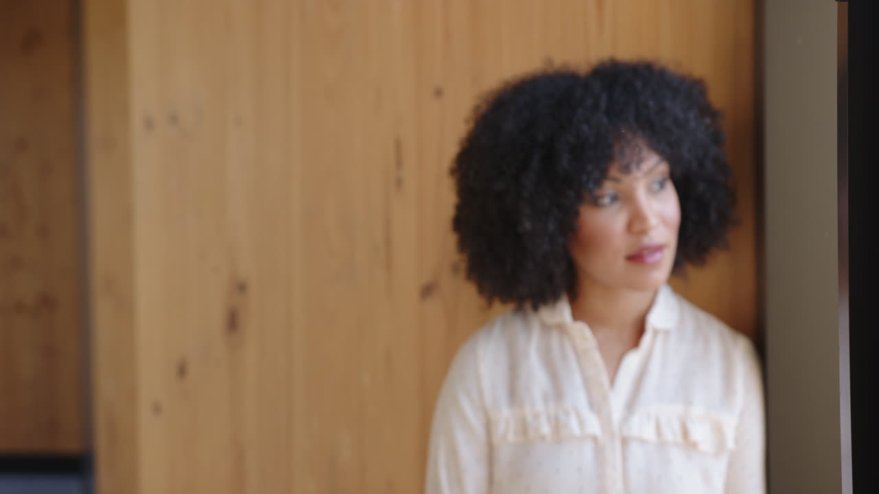 Thinking deeply, woman in polka dot blouse looking away in office setting