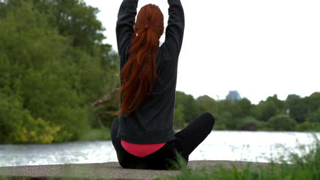 Pelirroja-Tranquila-Haciendo-Yoga-Junto-A-Un-Lago-