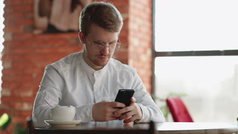 problematic internet use by modern smartphone adult man is sitting in cafe alone and chatting in social network