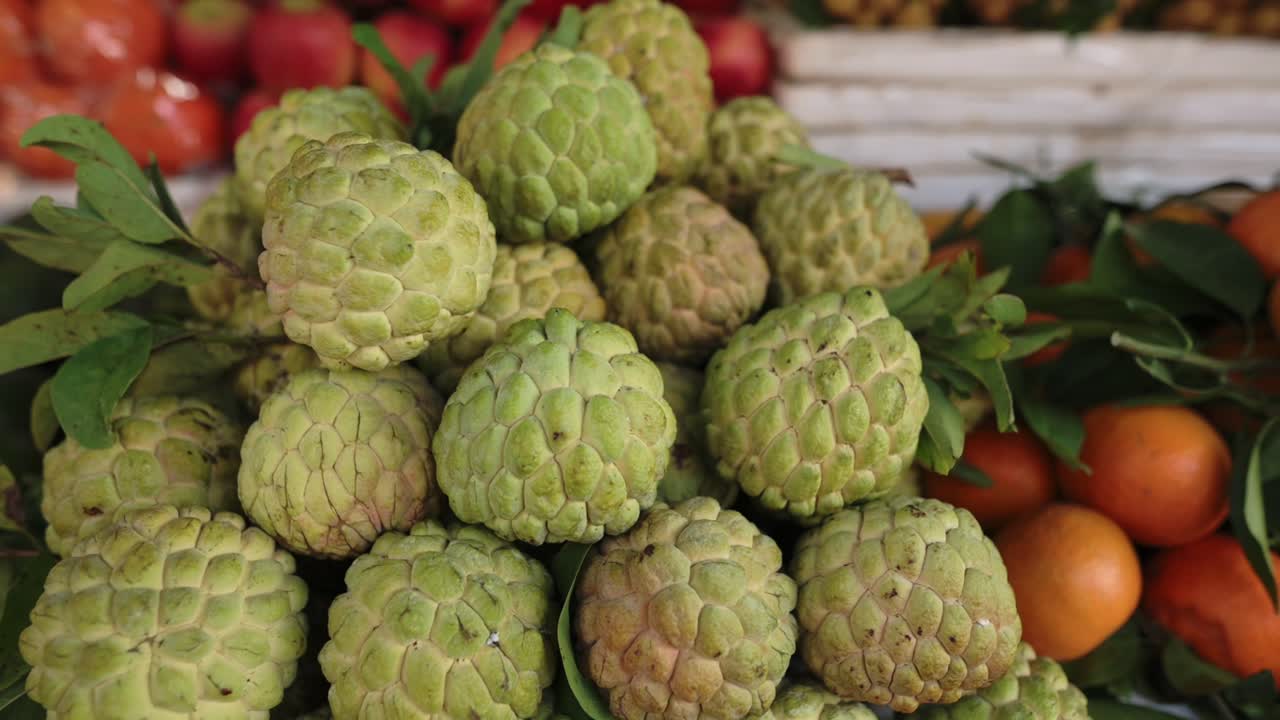 Pila di ananas selvatici al mercato di strada del Vietnam su cassetta, frutto verde bitorzoluto con foglie e accenti arancioni, primo piano di buccia irregolare e steli, esposizione rustica in legno, atmosfera di mercato biologico, tattile