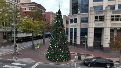 árbol de navidad en ciudad americana con bandera de estados unidos mientras cae la nieve