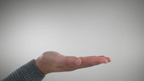 Man's-hand-with-palm-up-dressed-in-grey-jumper-on-grey-background