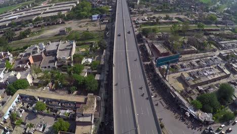 Aerial-over-the-bridge-in-the-urban-city,-India,-Green-trees-in-the-city-and-houses-top