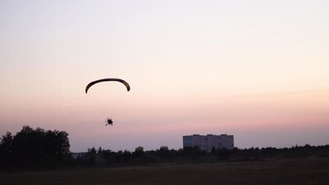 Der-Pilot-Eines-Gleitschirms-Fliegt-In-Den-Himmel-über-Sonnenuntergang-Und-Nachtlandschaft.-Hintergrund