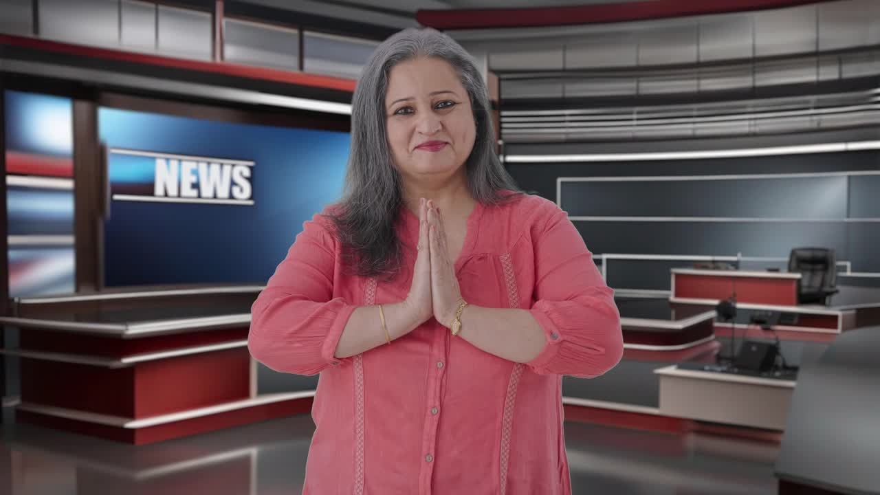 Feliz periodista india mayor haciendo Namaste y saludando.