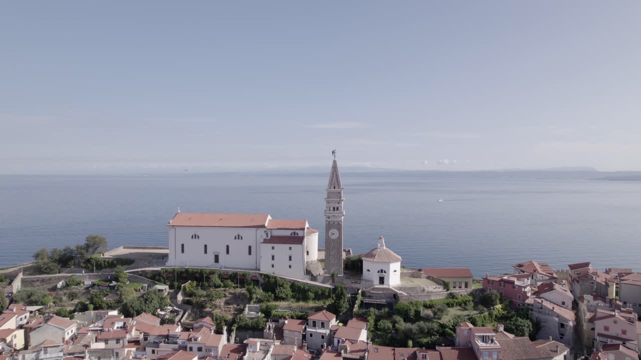 video con un dron de un avión retrocediendo sobre la ciudad de piran en eslovenia, comenzando con la iglesia como la principal y terminando desde arriba en el puerto deportivo pasando por la plaza central