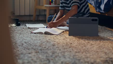child doing homework on floor
