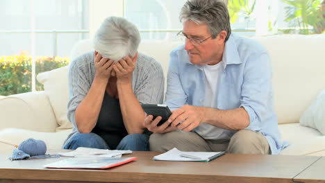 una pareja madura calculando sus cuentas domésticas.