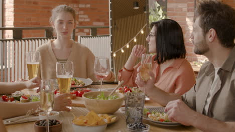 young woman tells a story to her group of friends at a dinner party