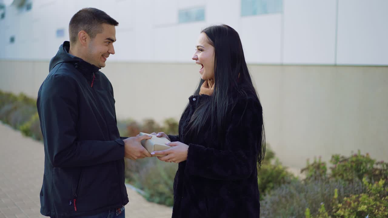 man bestows gift for a woman when they meet in the street on St. Valentine's Day