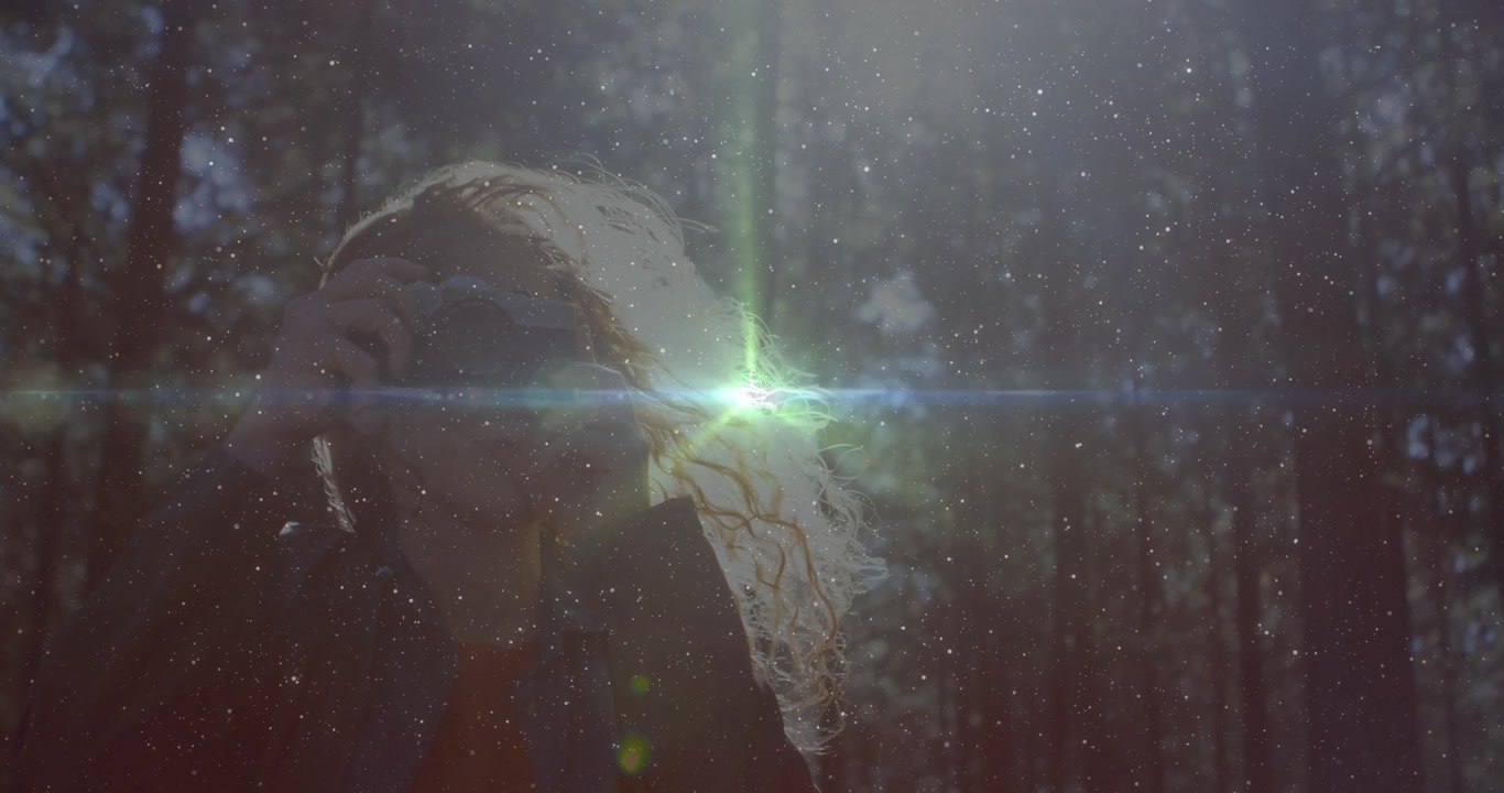 Female photographer raising camera and framing forest with green lens flare for capturing sunlight