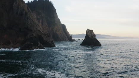 Vuelo-Bajo-Entre-La-Aguja-Rocosa-Que-Se-Eleva-Desde-El-Océano-Pacífico-Y-El-Acantilado-De-La-Costa-De-Oregon