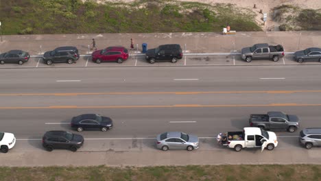 4K-Drohnenansicht-Von-Autos,-Die-Auf-Dem-Seawall-Blvd-In-Galveston,-Texas,-Fahren