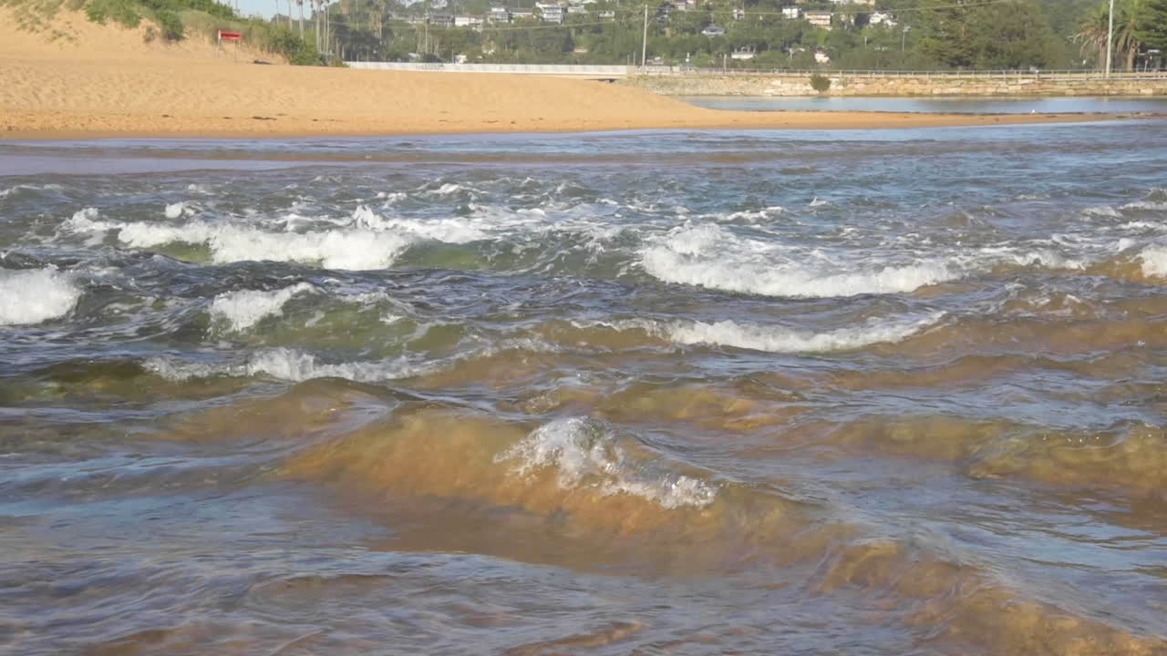 punto de vista desde dentro de las olas siendo azotado dentro de las olas rodeado de arena y burbujas y espuma de olas
