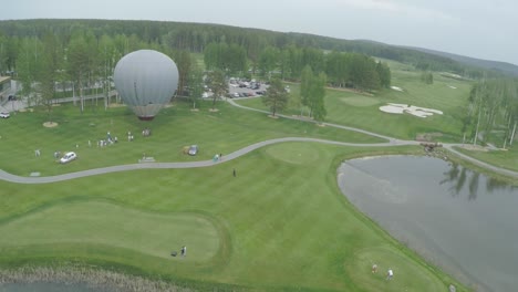 aerial view of golf course with hot air balloon