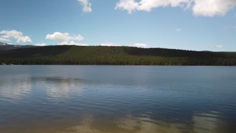 Panning-view-of-Park-Reservoir-in-summer-with-Clouds-Peak-Wilderness-in-the-background-in-Bighorn-National-Forest-in-Wyoming