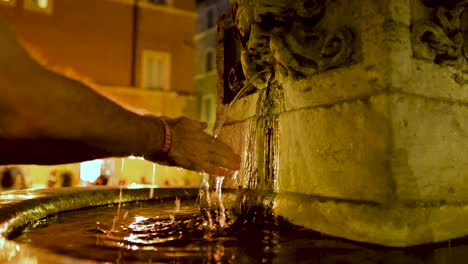Slow Motion Close Tight Shot of Young Man Washing Hands in Italian Street Fountain at Night