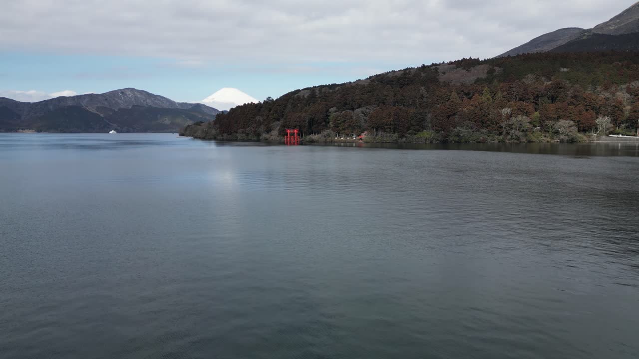 Vista serena do Lago Ashi com superfície de água calma e floresta de montanha ao fundo. Paisagem natural tranquila na região de Hakone. Céu nublado criando uma atmosfera melancólica no lago vulcânico japonês.
