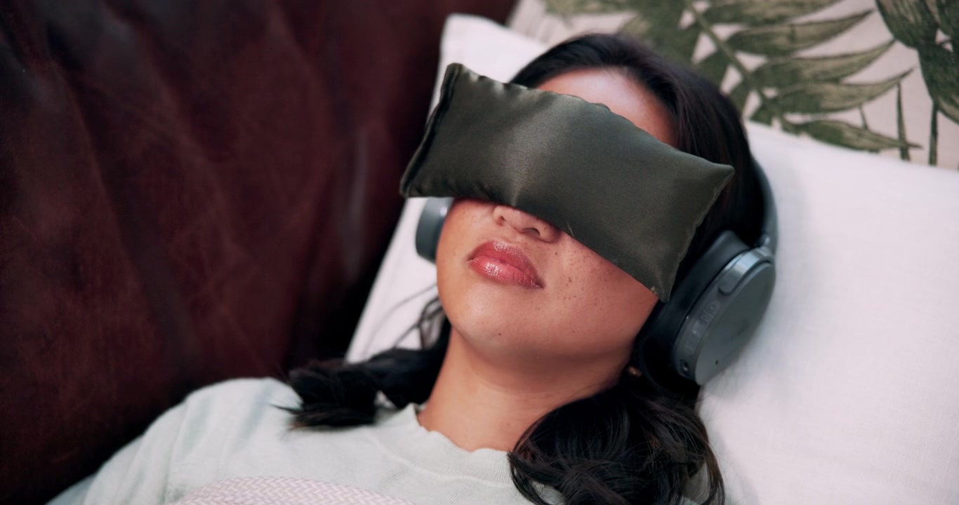 Young Woman Relaxing at Home with Eye Mask and Headphones