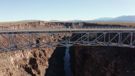 Aerial-rising-above-scenic-Rio-Grande-gorge-bridge-as-cars-travel-across