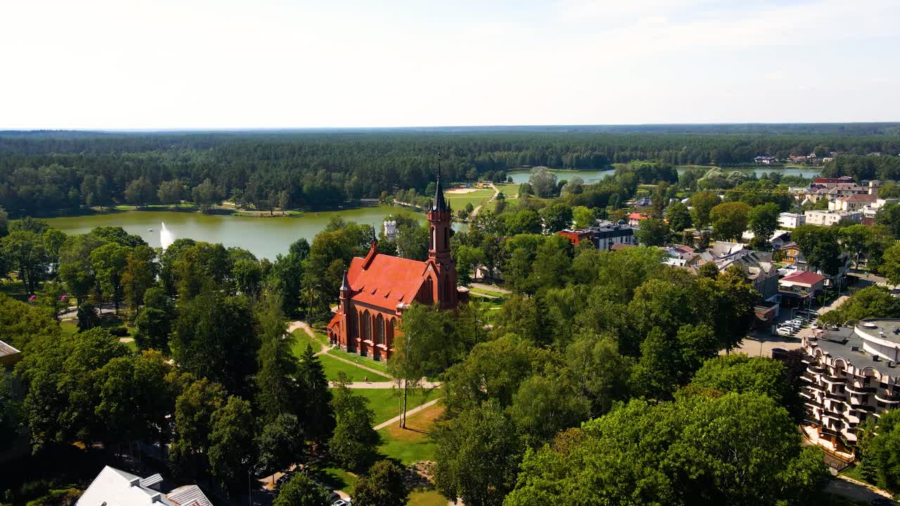 Aerial shot of the Catholic Church of Saint Mary's Scapular in Druskininkai, Lithuania on a sunny summer day, parallax